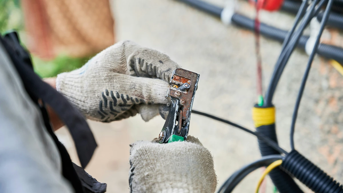 A Close-Up Of An Electrician Repairing An Electrical Hazard.