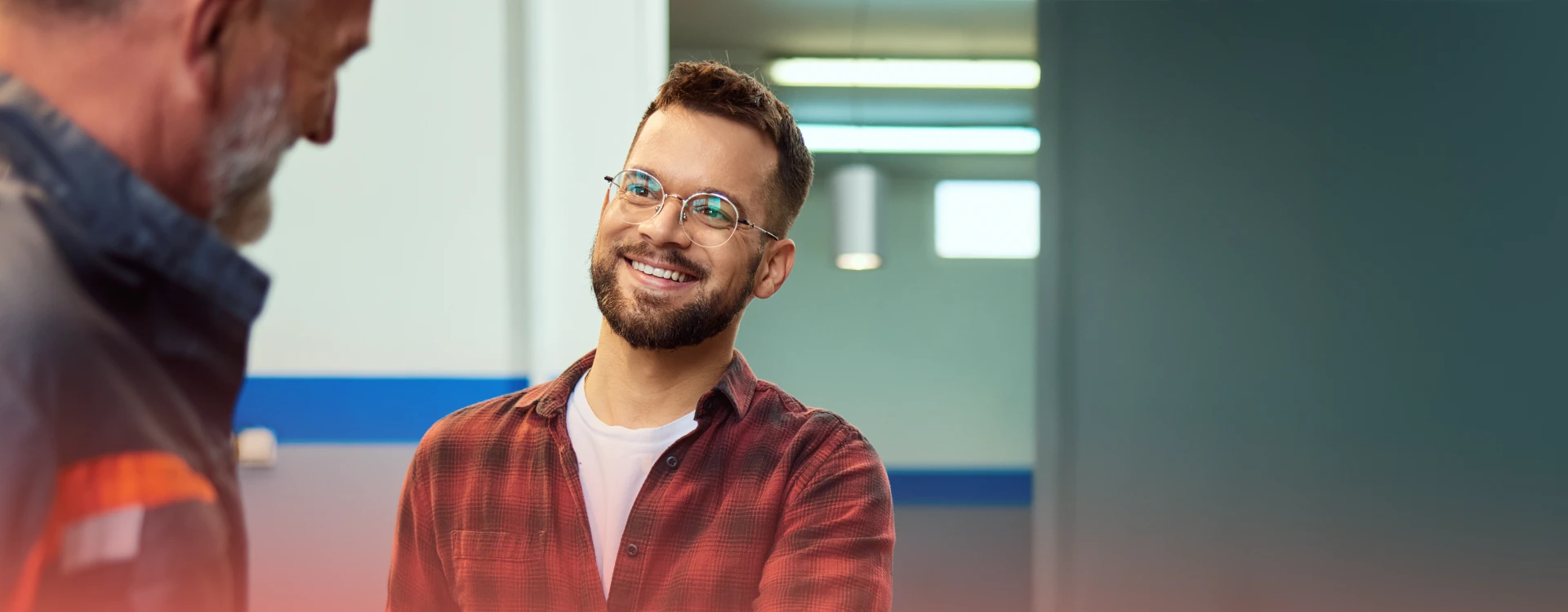 A Young Man Greeting A Smiling Electrician.