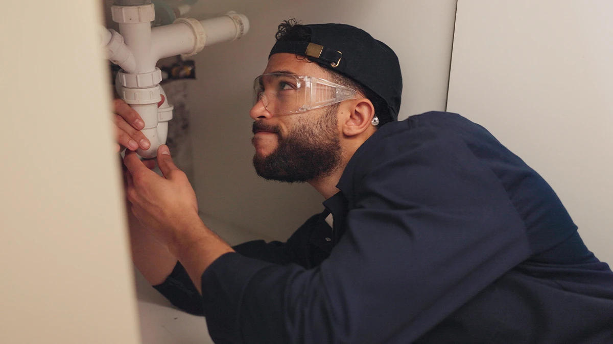 A Plumber Fixing A Burst Pipe.