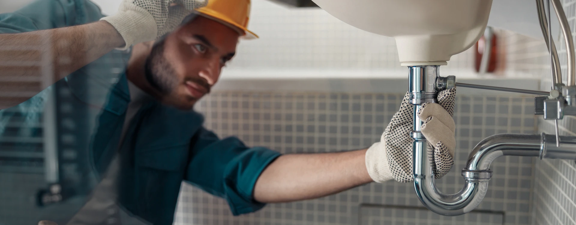 Emergency Plumber Repairing Bathroom Leak.